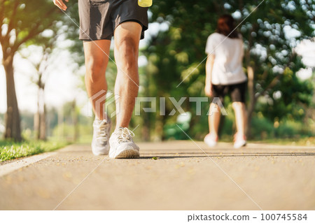 man jogging and walking on the road at morning with Energy Drink water, adult male in sport shoes running in the park outside. Exercise, wellness, healthy lifestyle and wellbeing concepts man jogging and walking on the road at morning with Energy Drink water, adult male in sport shoes running in the park outside. Exercise, wellness, healthy lifestyle and wellbeing concepts 100745584