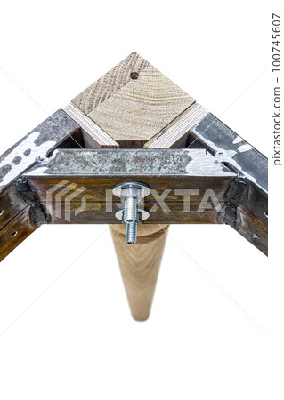 Wooden carved leg of solid oak with metal table frame during manufacturing process of dining table isolated on white background Wooden carved leg of solid oak with metal table frame during manufacturing process of dining table isolated on white background 100745607