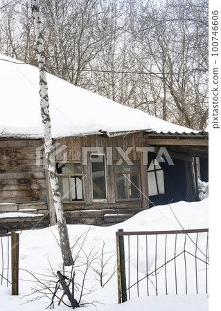 An old wooden abandoned house covered with snow in a birch forest in winter An old wooden abandoned house covered with snow in a birch forest in winter 100746606
