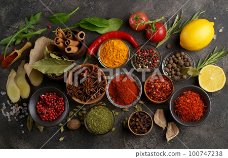 Set of spices and herbs. Indian food. Pepper, salt, paprika, basil, turmeric. On a black wooden board. View from above. Free copy space. 100747238