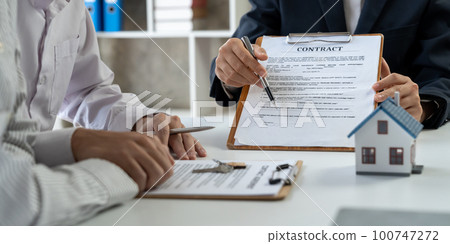 Happy couple signing a contract with real estate agent. renters tenants sign mortgage loan investment agreement or rental insurance contract meeting realtor lender landlord making real estate sale 100747272