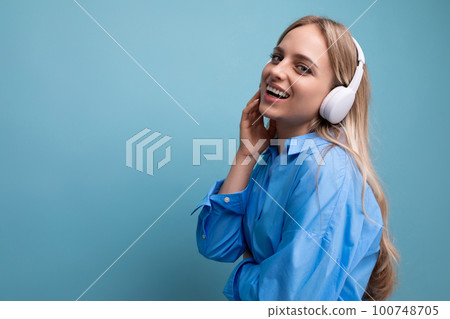 close-up of a European girl in wireless large headphones in a casual outfit enjoys and relaxes to 100748705