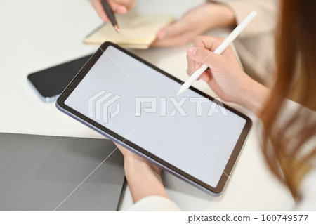 Close up view of creative woman holding stylus pen pointing at blank digital tablet screen 100749577