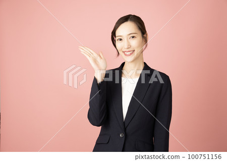 身穿藏青色西裝背粉色指右指的女子 100751156
