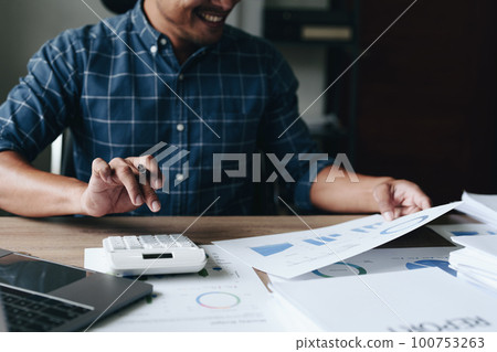 financial, Planning, Marketing and Accounting, portrait of Asian woman Economist using calculator to calculate investment documents with partners on profit taking to compete with other companies. financial, Planning, Marketing and Accounting, portrait of Asian woman Economist using calculator to calculate investment documents with partners on profit taking to compete with other companies. 100753263