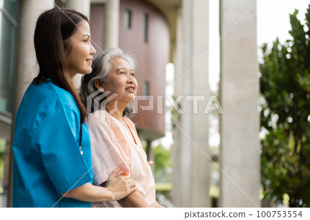 Asian careful caregiver or nurse hold patient hand and encourage patient, walking in garden. Concept of happy retirement with care from a caregiver and Savings and senior health insurance. Asian careful caregiver or nurse hold patient hand and encourage patient, walking in garden. Concept of happy retirement with care from a caregiver and Savings and senior health insurance. 100753554