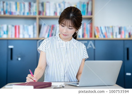 在圖書館使用筆記本電腦的年輕女性 100753594