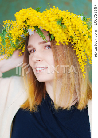 middle-aged woman in a wreath of mimosa 100753687