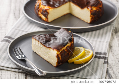 Basque cheesecake with a creamy center and a deeply caramelized crust top and bottom closeup on the plate. Horizontal Basque cheesecake with a creamy center and a deeply caramelized crust top and bottom closeup on the plate. Horizontal 100756078