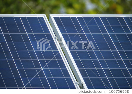 Solar photovoltaic panels mounted on stand-alone frame on backyard ground for generating of clean ecological electric energy. Concept of autonomous house Solar photovoltaic panels mounted on stand-alone frame on backyard ground for generating of clean ecological electric energy. Concept of autonomous house 100756968