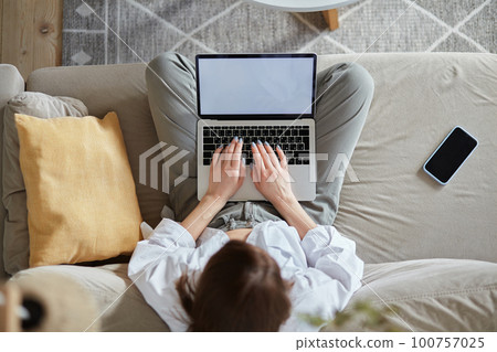 Mockup white screen laptop woman using computer sitting on sofa at home, top view 100757025