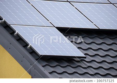 Residential house with rooftop covered with solar photovoltaic panels for producing of clean ecological electrical energy in suburban rural area. Concept of autonomous home 100757125