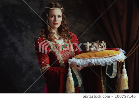 medieval queen in red dress with crown on pillow 100757146
