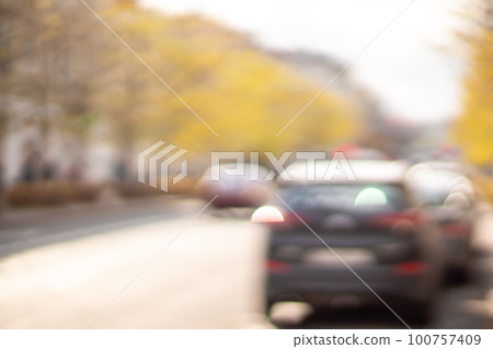 Autumn season bokeh background. Abstract city blur along the road with cars. 100757409