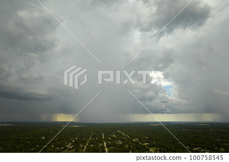 Landscape of dark ominous clouds forming on stormy sky during heavy thunderstorm over rural town area 100758545