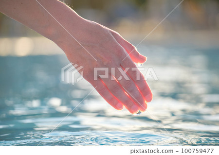 Female hand touching water of swimming pool in summer Female hand touching water of swimming pool in summer 100759477