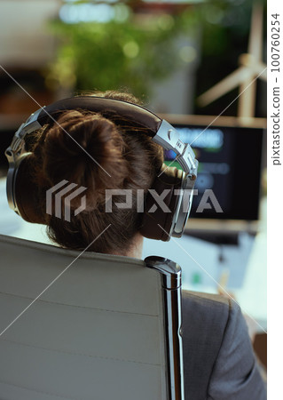 Closeup on modern woman listening to music with headphones Closeup on modern woman listening to music with headphones 100760254