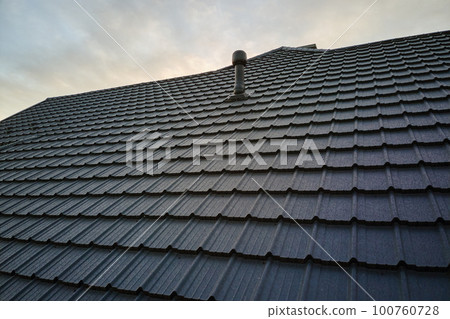 Closeup of house roof top covered with metallic shingles.Tiled covering of building 100760728