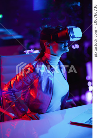 curious female in virtual reality goggles in office 100760736