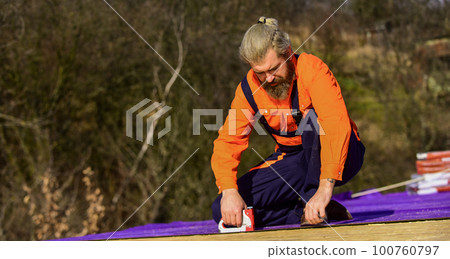 Assemble temporary equipment or structures. Structural sheathing. Fix or build. Roofer repair roof. Roof installation. Bearded man work outdoor. Roof Mechanic concept. Inspect repair and replace 100760797