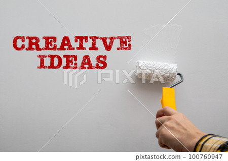 Creative Ideas concept. Paint a white wall with a paint roller 100760947