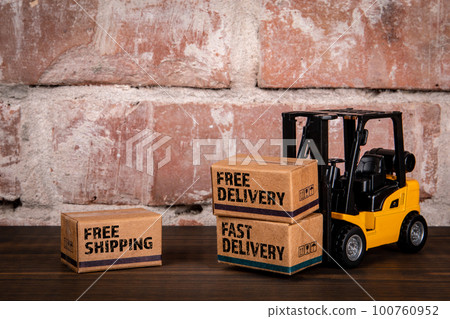 Delivery service and sales concept. Miniature cardboard boxes on a wooden table 100760952