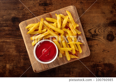 French fries, potato snack with ketchup, fast food on a wooden table French fries, potato snack with ketchup, fast food on a wooden table 100760985
