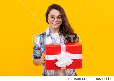 happy teen girl with present isolated on yellow background. teen girl in glasses with present 100761112