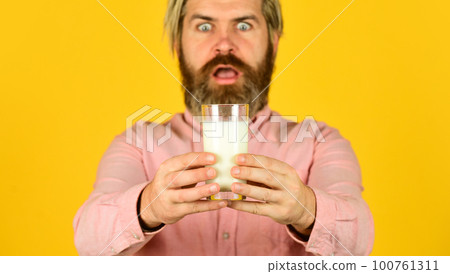 Milk Pasteurization in Dairy Processing Plant. selective focus. surprised man hold glass of milk. pasteurized milk. Man offer tasty vegan glass. buy milk in supermarket 100761311