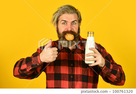 milk and cookies. happy farmer eat cookie dessert. bearded man drink useful milk with pastry. The concept of healthy eating Organic farm products for Breakfast or lunch milk and cookies. happy farmer eat cookie dessert. bearded man drink useful milk with pastry. The concept of healthy eating Organic farm products for Breakfast or lunch 100761320