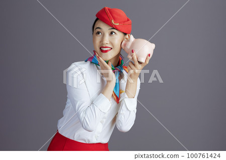 cheerful asian female flight attendant against gray cheerful asian female flight attendant against gray 100761424