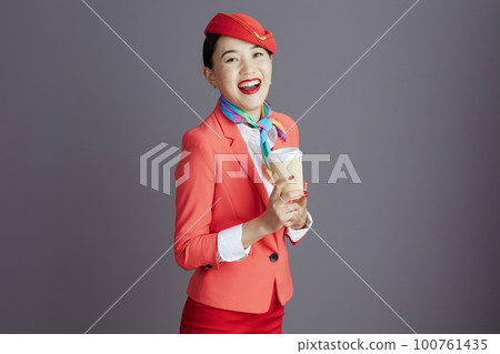 smiling modern asian female stewardess isolated on grey 100761435