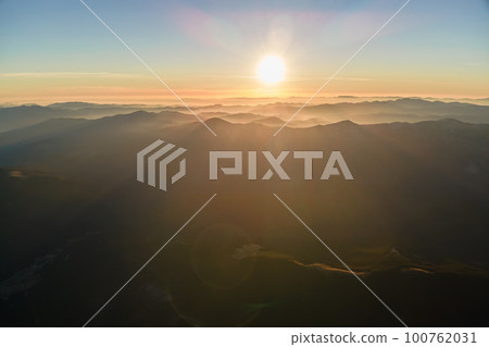 Beautiful mountain panoramic landscape with hazy peaks and foggy valley at sunset 100762031