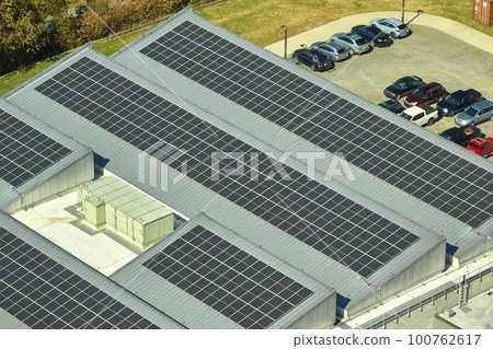 Aerial view of solar power plant with blue photovoltaic panels mounted on industrial building roof for producing green ecological electricity. Production of sustainable energy concept 100762617