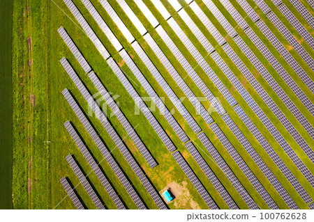 Aerial view of solar power plant on green field. Electric panels for producing clean ecologic energy. 100762628