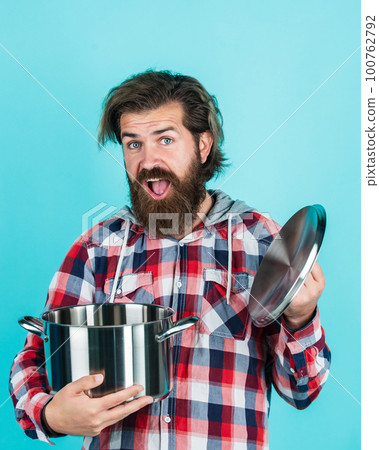wow. man holding frying pan.. male chef kitchener cooking. hipster checkered shirt for bearded guy cook. unshaven brutal man with kitchen utensil. household goods. friendly shop assistant wow. man holding frying pan.. male chef kitchener cooking. hipster checkered shirt for bearded guy cook. unshaven brutal man with kitchen utensil. household goods. friendly shop assistant 100762792
