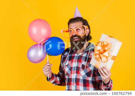Buying and selling. Party Elements and holiday objects. Multi colored fun. best party for retirement. cheerful man with beard hold present. hipster smiling with balloon. Celebrating happy party Buying and selling. Party Elements and holiday objects. Multi colored fun. best party for retirement. cheerful man with beard hold present. hipster smiling with balloon. Celebrating happy party 100762794