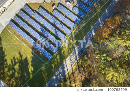 Aerial view of large sustainable electrical power plant with rows of solar photovoltaic panels for producing clean electric energy. Concept of renewable electricity with zero emission Aerial view of large sustainable electrical power plant with rows of solar photovoltaic panels for producing clean electric energy. Concept of renewable electricity with zero emission 100762799