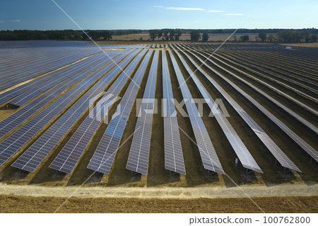 Aerial view of large sustainable electrical power plant with rows of solar photovoltaic panels for producing clean electric energy. Concept of renewable electricity with zero emission Aerial view of large sustainable electrical power plant with rows of solar photovoltaic panels for producing clean electric energy. Concept of renewable electricity with zero emission 100762800