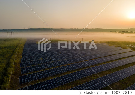 Aerial view of large sustainable electrical power plant with rows of solar photovoltaic panels for producing clean electric energy in evening. Concept of renewable electricity with zero emission 100762810