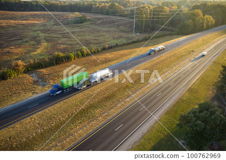 Aerial view of busy american freeway with fast moving cars and trucks. Interstate hauling of goods concept 100762969