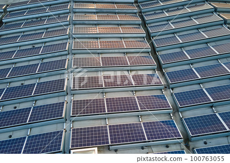 Aerial view of blue photovoltaic solar panels mounted on industrial building roof for producing green ecological electricity. Production of sustainable energy concept Aerial view of blue photovoltaic solar panels mounted on industrial building roof for producing green ecological electricity. Production of sustainable energy concept 100763055
