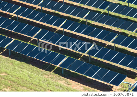 Aerial view of big sustainable electric power plant with many rows of solar photovoltaic panels for producing clean electrical energy. Renewable electricity with zero emission concept 100763071