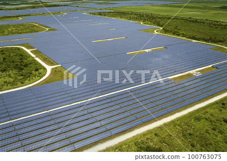 Aerial view of big sustainable electric power plant with many rows of solar photovoltaic panels for producing clean electrical energy. Renewable electricity with zero emission concept 100763075