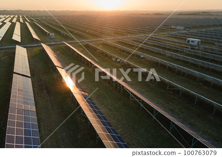 Aerial view of big sustainable electric power plant with many rows of solar photovoltaic panels for producing clean electrical energy at sunset. Renewable electricity with zero emission concept Aerial view of big sustainable electric power plant with many rows of solar photovoltaic panels for producing clean electrical energy at sunset. Renewable electricity with zero emission concept 100763079