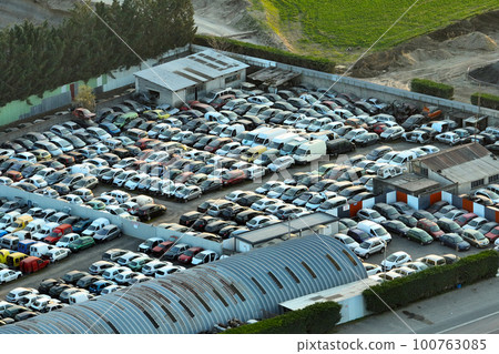 Aerial view of big parking lot of junkyard with rows of discarded broken cars. Recycling of old vehicles 100763085