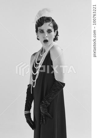 Closeup portrait of shocked woman wearing old-time clothes standing and looking with angry face. Monochrome 100763221