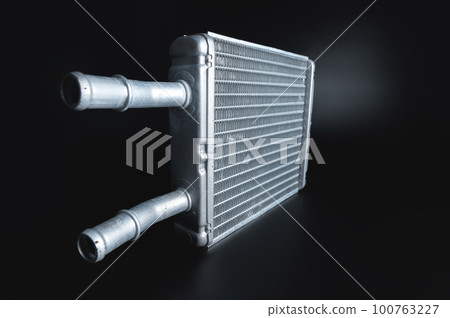 radiator of the heating and air conditioning system of the car, radiator of the car interior stove, close-up on a black background, selective focus 100763227