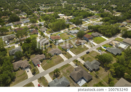 Aerial landscape view of suburban private houses between green palm trees in Florida quiet rural area Aerial landscape view of suburban private houses between green palm trees in Florida quiet rural area 100763240