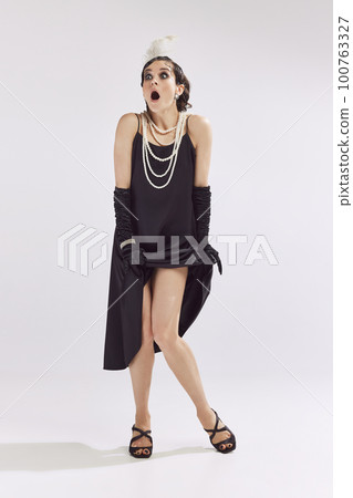 Photo of beautiful fashionable woman wearing old-time clothes standing and looking with scared face at camera over white background Photo of beautiful fashionable woman wearing old-time clothes standing and looking with scared face at camera over white background 100763327